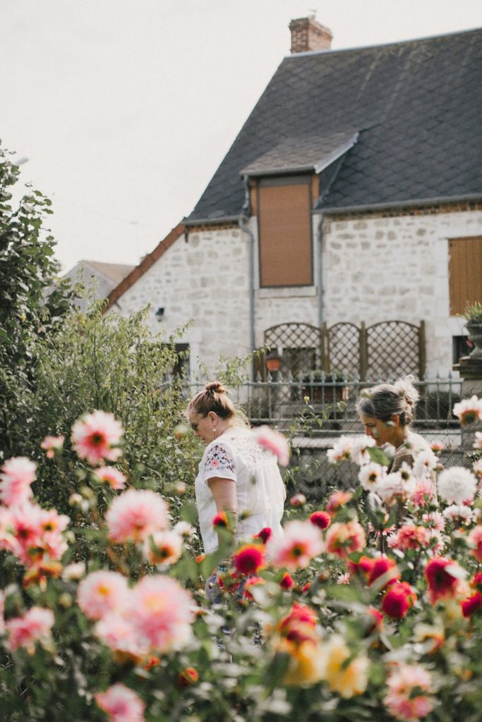 Attendees walk through a flower garden during The Secret Garden retreat