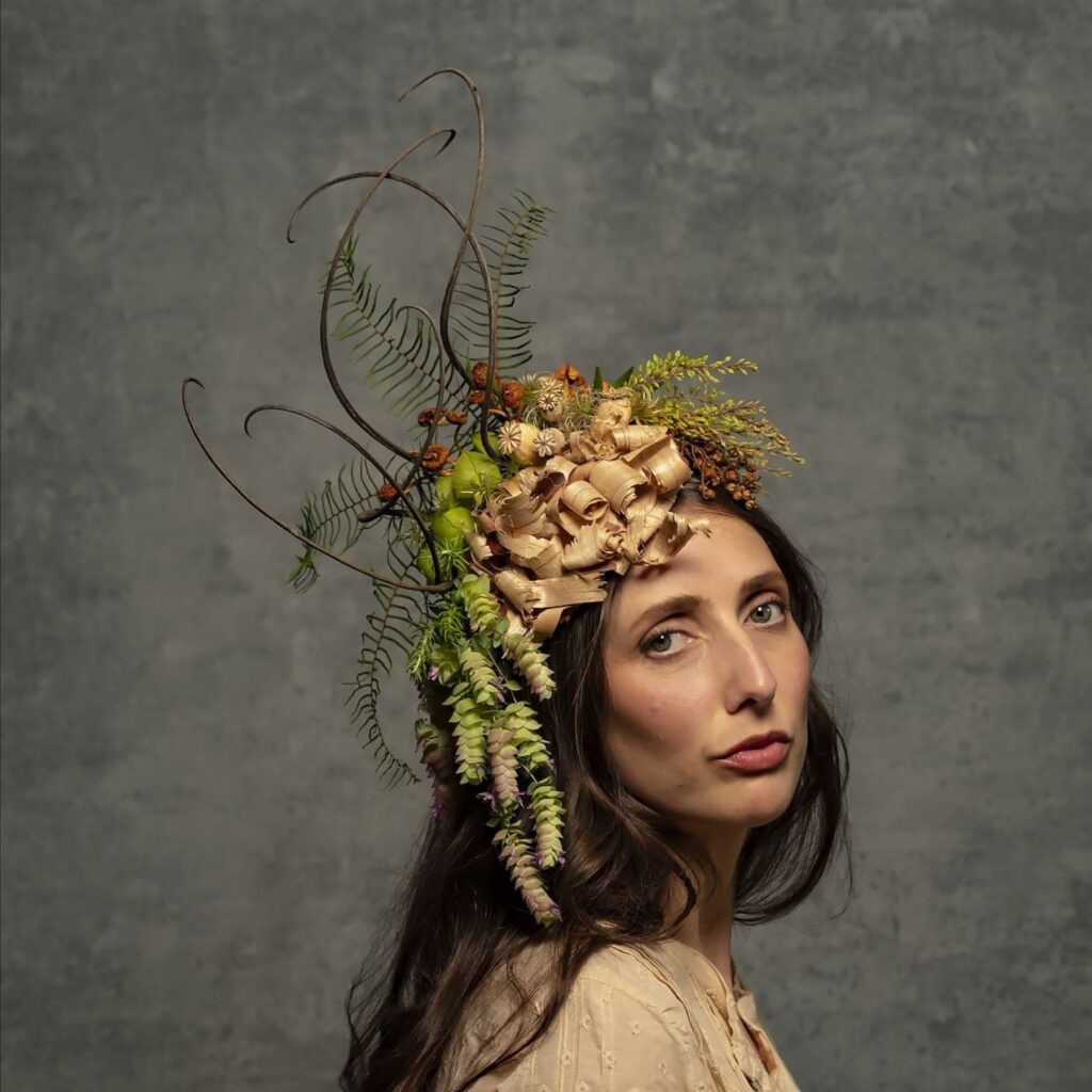 Botanical headdress designed by Françoise Weeks using poppy pods, wood shavings, ferns, and plants